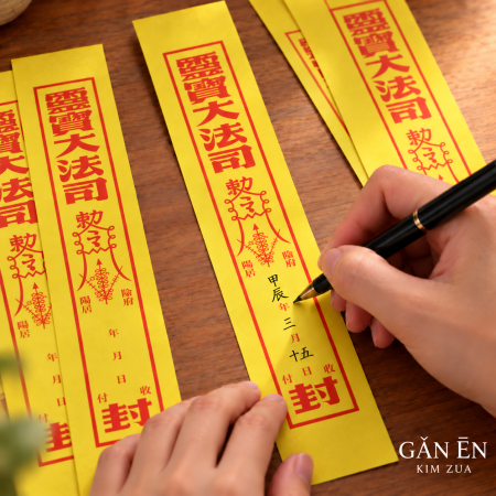 Writing on yellow Feng Tiao paper with a black pen